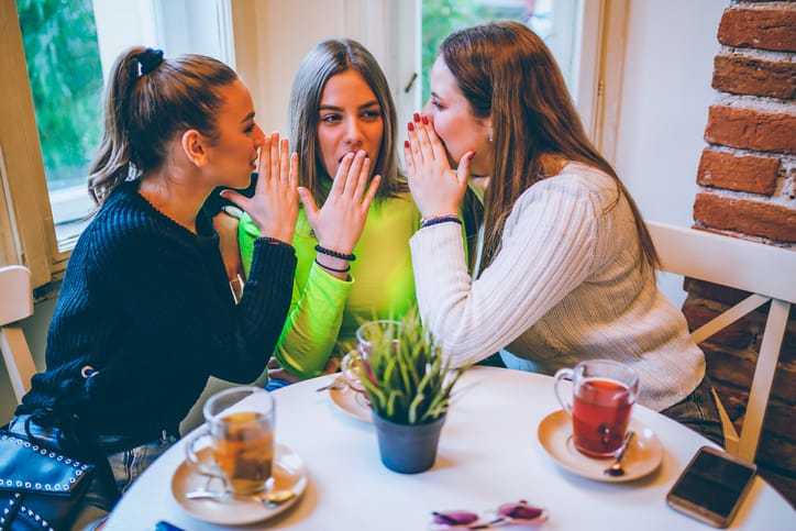 Gossiping girl friends in a cafe.