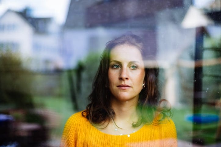 Young woman looks thoughtfully and sadly