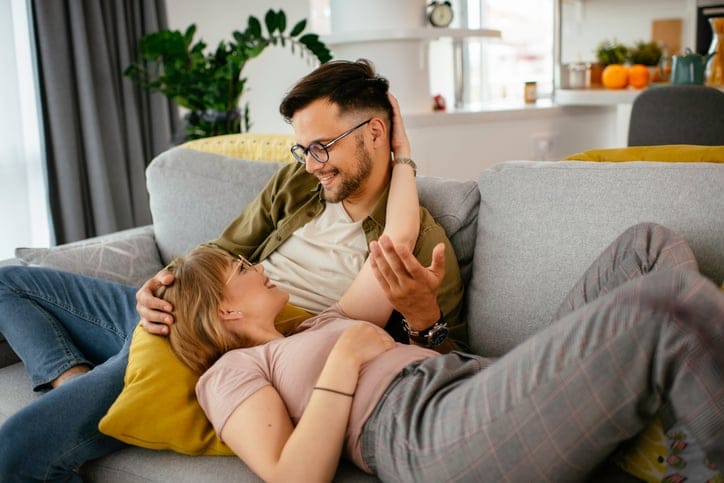 Young loving couple on sofa. Happy couple relaxing in living room.