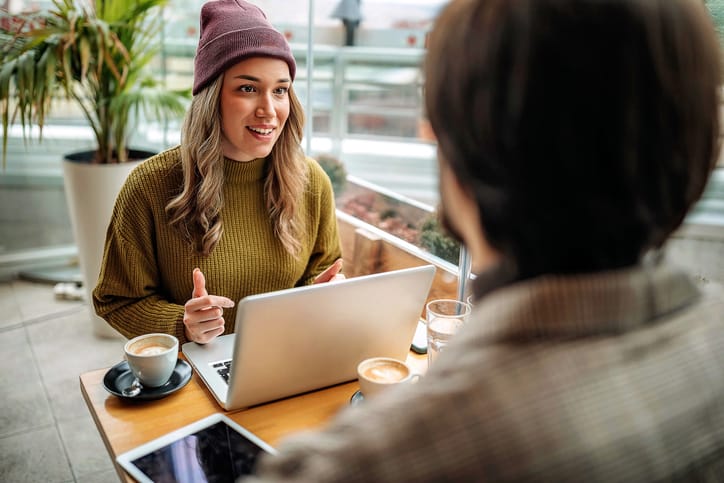 Young couple doing freelance work in cafe