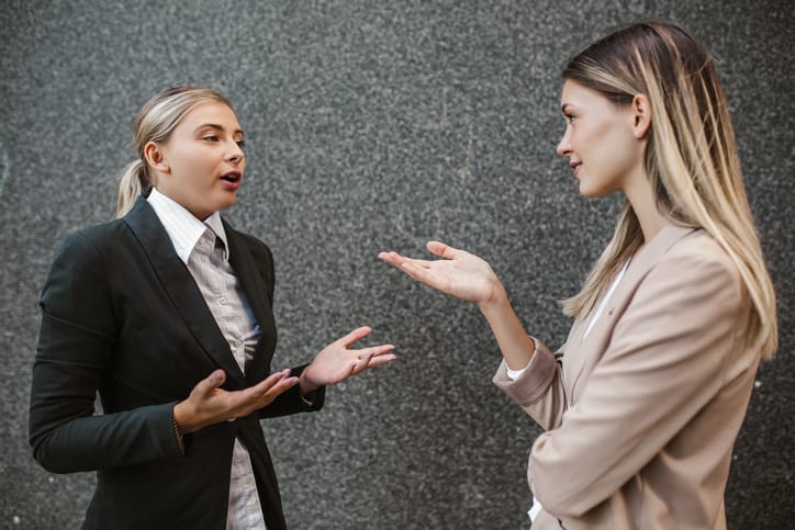 Caucasian woman assistant talking and discussing work to businesswoman.