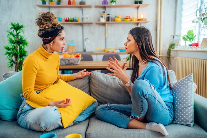 female friends arguing on couch