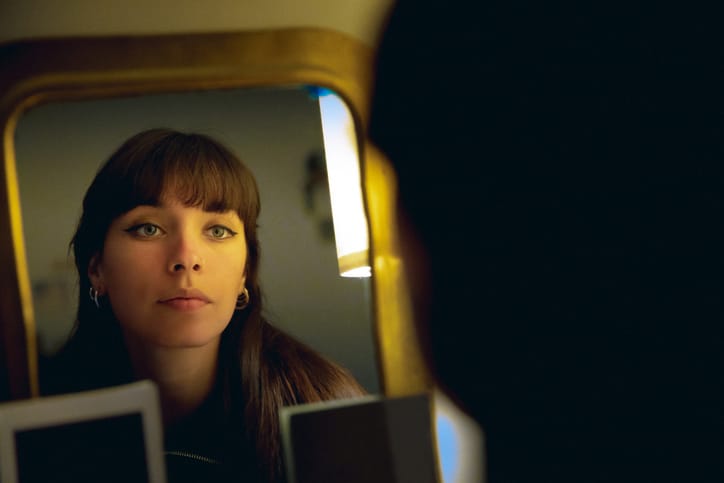 serious woman looking in mirror