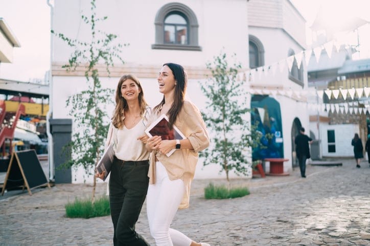 two friends walking outside in city