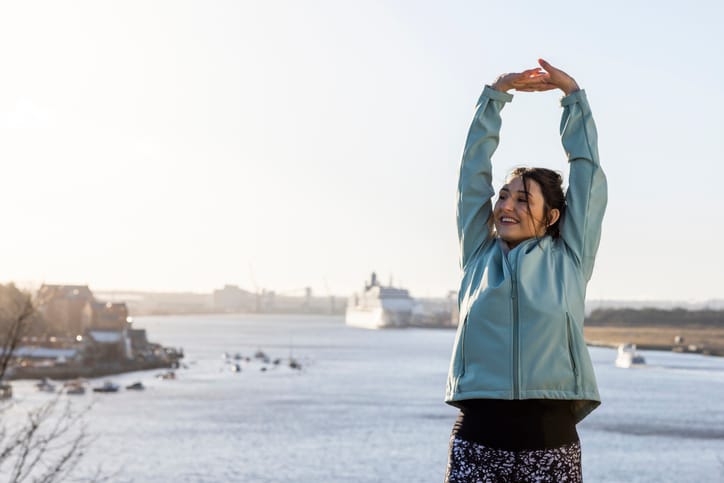 woman stretching outdoors in sunshine