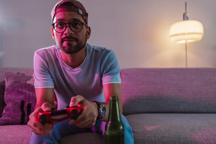 millennial man playing video games on couch