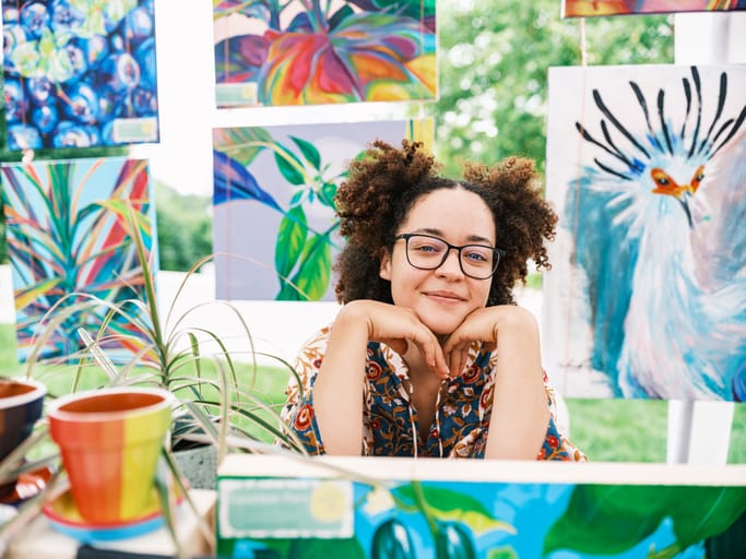 Young woman artist selling her art at Outdoor Market.