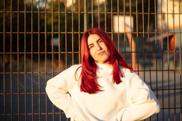 redhead woman with hands on hips outside