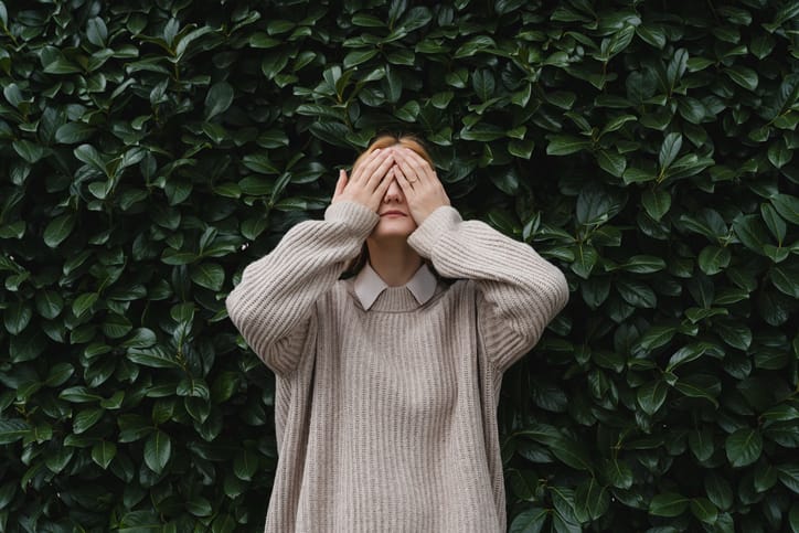 Portrait of relaxed woman with eyes closed on background of green leaves wall. Concept of outside of office, Work-Life-Balance, Taking Break. Zen and balance people. Stability through mental health.