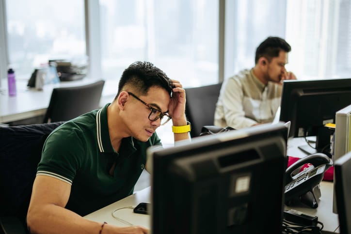two men working on computers in office