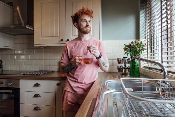 Man standing in his kitchen in the morning.