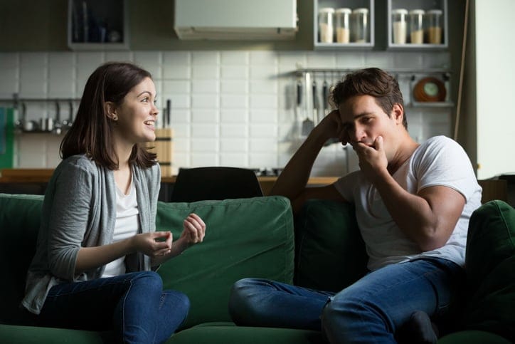 bored man yawning as girlfriend speaks