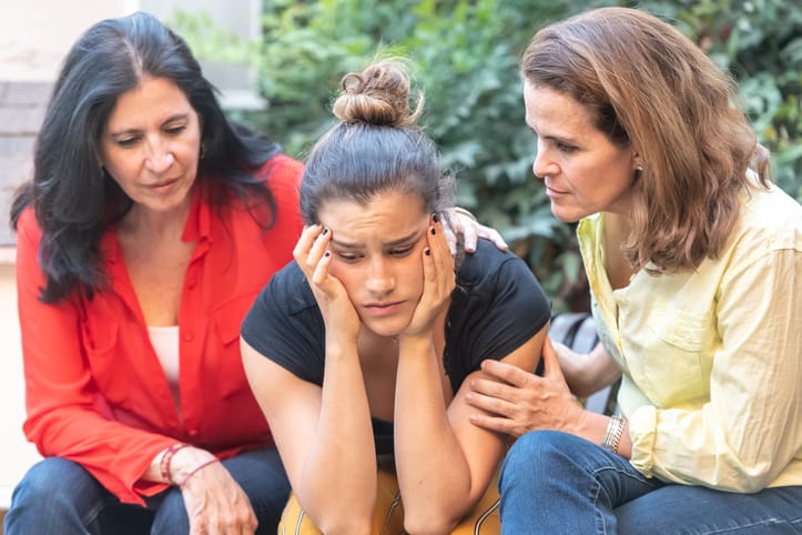 Mature women consoling their daughter