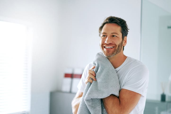 Man going through is morning routine in the bathroom.