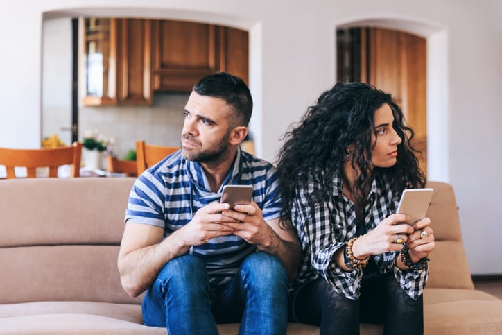 Mid adult Couple having problems, using smart phones
