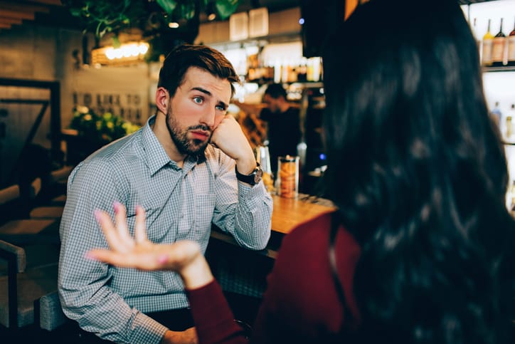man with cocked eyebrow looking at woman