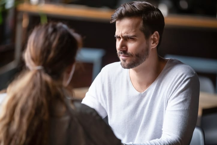 Skeptical man looking at a woman.