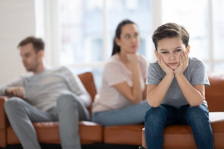 Upset child boy sad about parents fights.