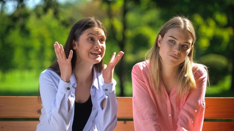 two friends having a talk on bench