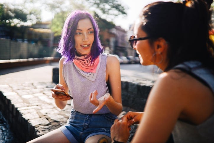 woman telling her friend some gossip