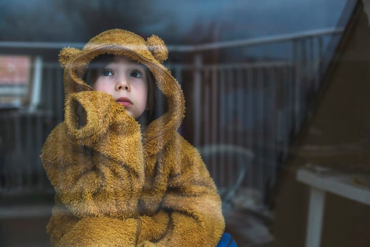 Upset boy looking through the window.