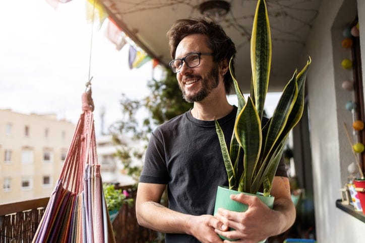 guy with plant on balcony