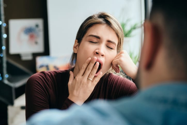 woman yawning while man is talking