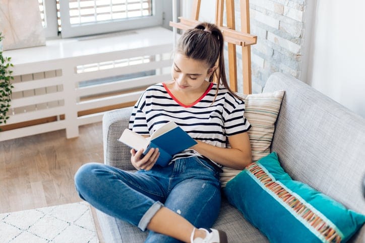 Portrait of a beautiful girl enjoying reading a book at home.
