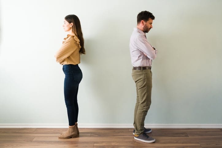Couple with their backs turned and angry expression.