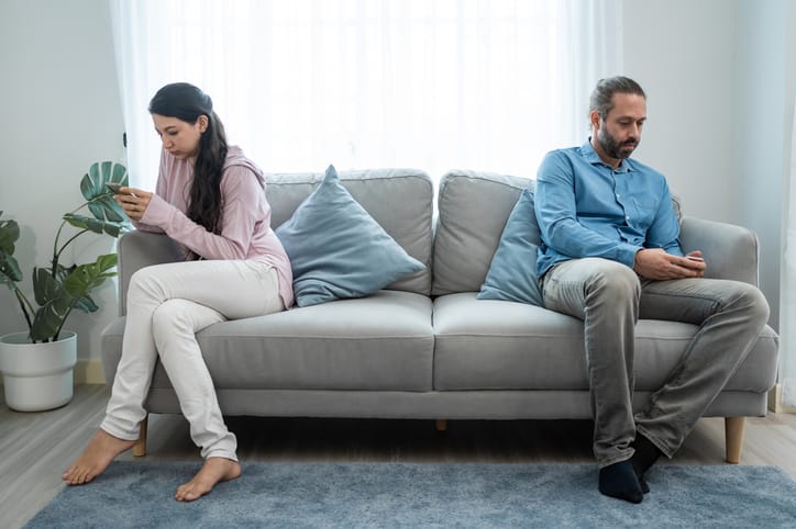 sitting apart on the sofa couple