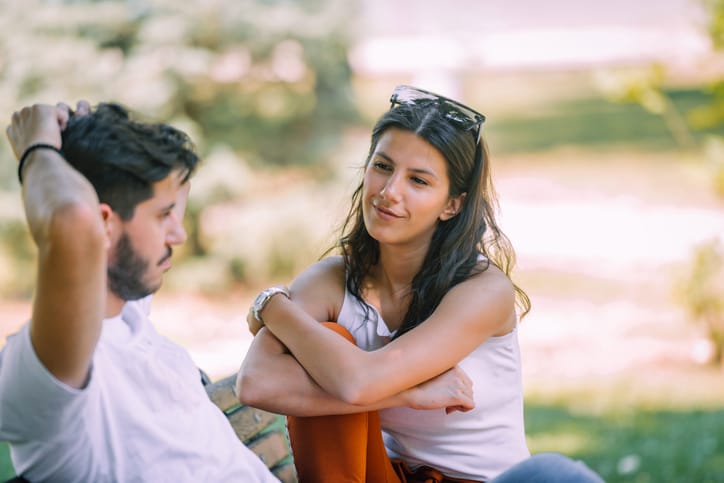Caucasian beautiful guy and woman resting in the park in the summer