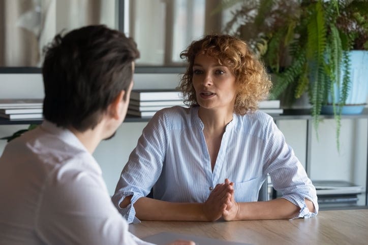 man and woman talking at table