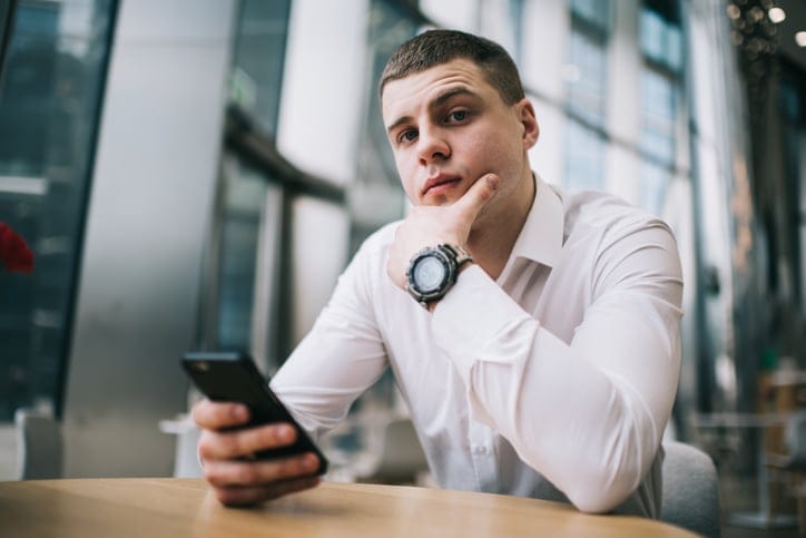 young businessman using phone looking serious