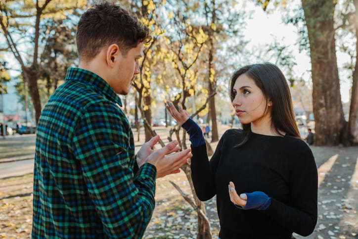 young couple arguing in woods