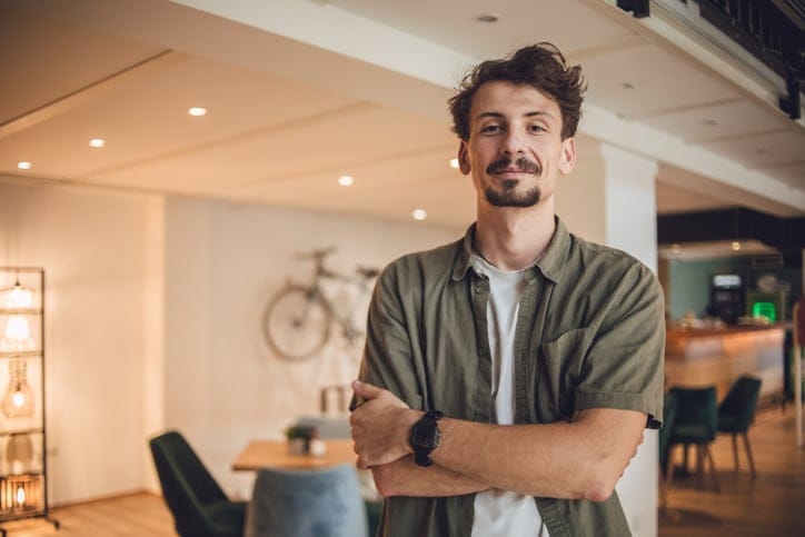 man arms crossed in office