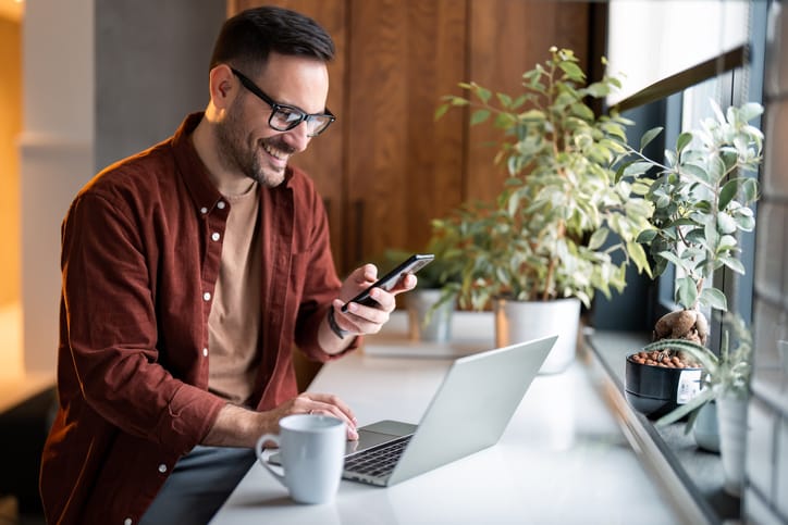 Man on laptop and cell phone.