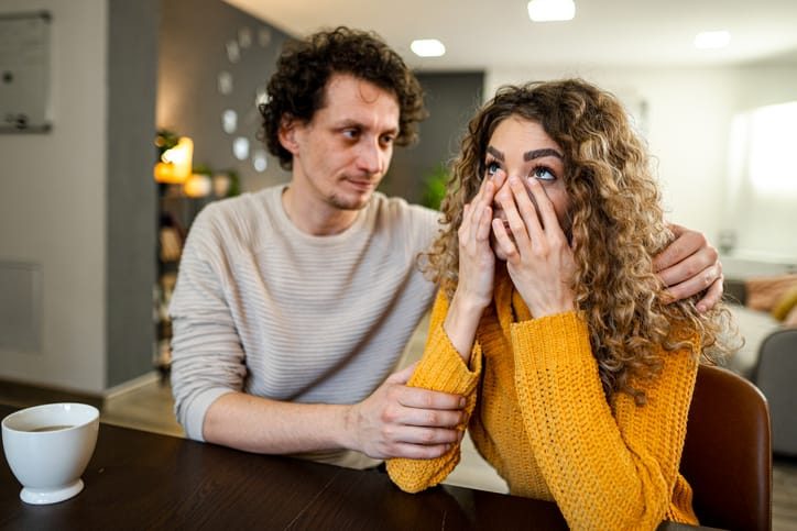 Loving husband comforting his crying wife.