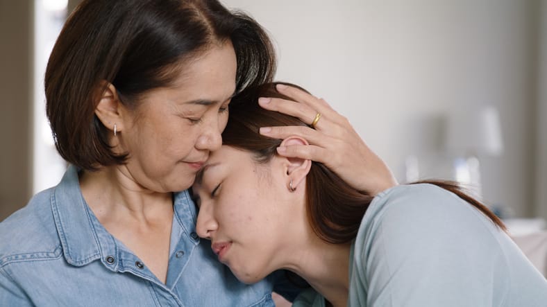 woman being comforted by her mother