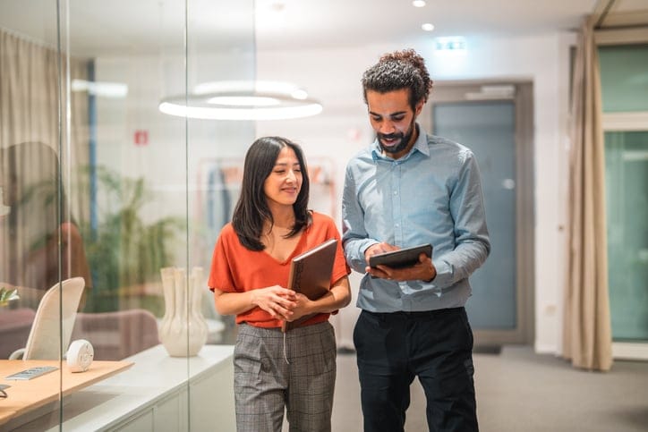 two colleagues walking in office