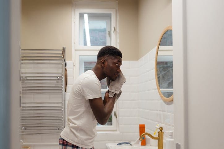 guy washing his face in the mirror