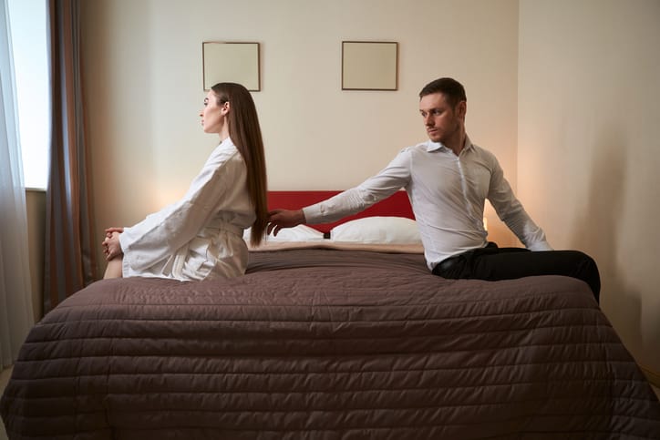 Married couple having argument in bedroom.