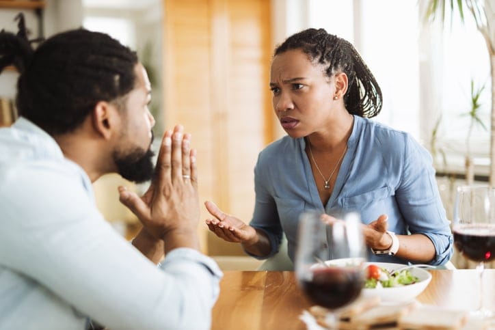 angry couple arguing at dinner table