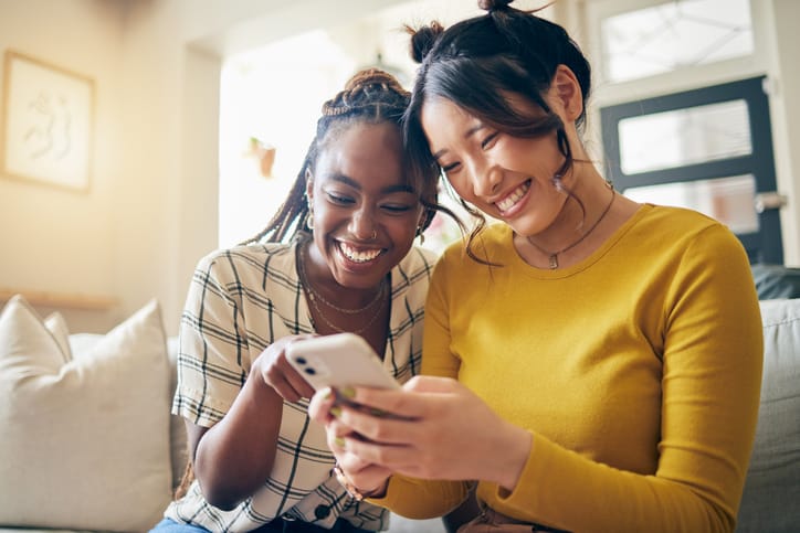 two female friends laughing at phone