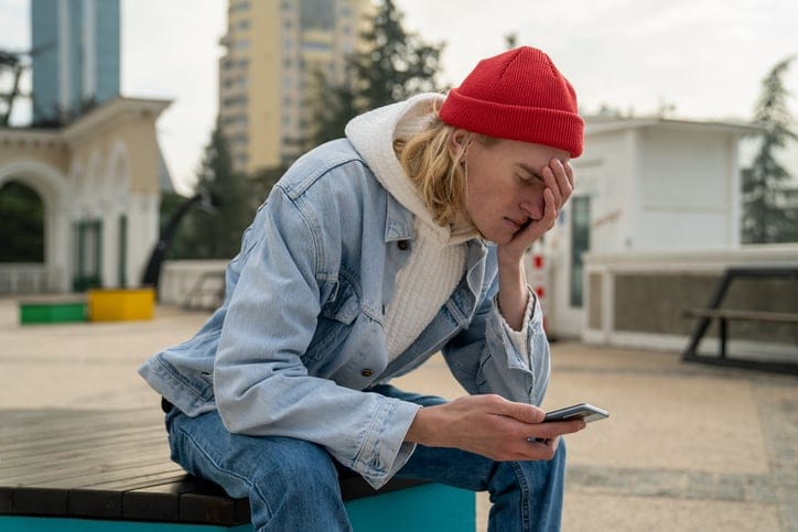 guy covering his face with phone