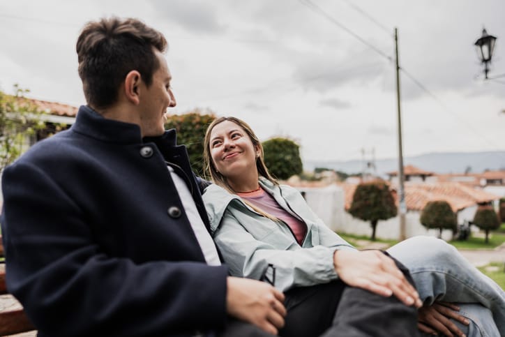 young couple chatting on park bench