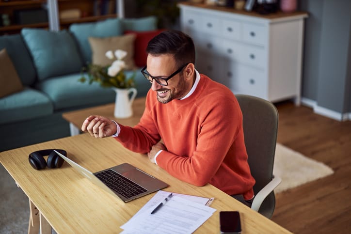 Man sitting on her desk at his computer.