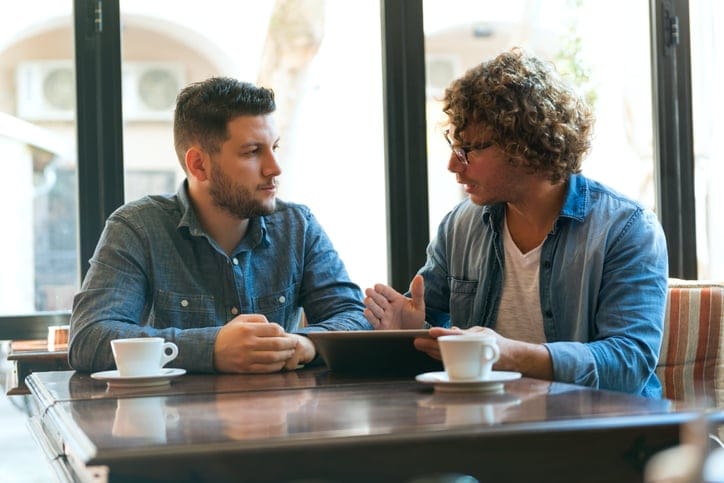 Two young Men Exchange ideas in a Cafe