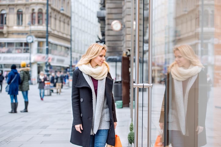 Beautiful young woman window shopping in historical centre of the city of Vienna, Austria. Winter.
