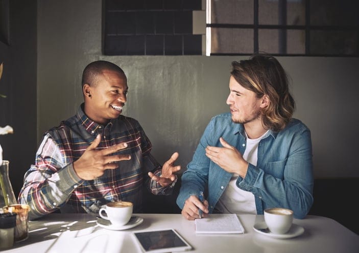 two male friends talking at restaurant