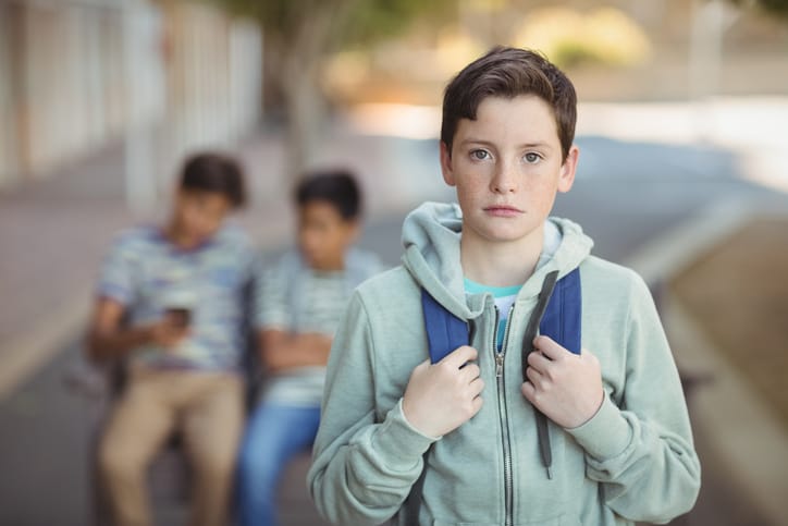lonely schoolboy in school yard